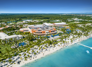 Sky view of the convention centre with a lot of palm trees and the beach.